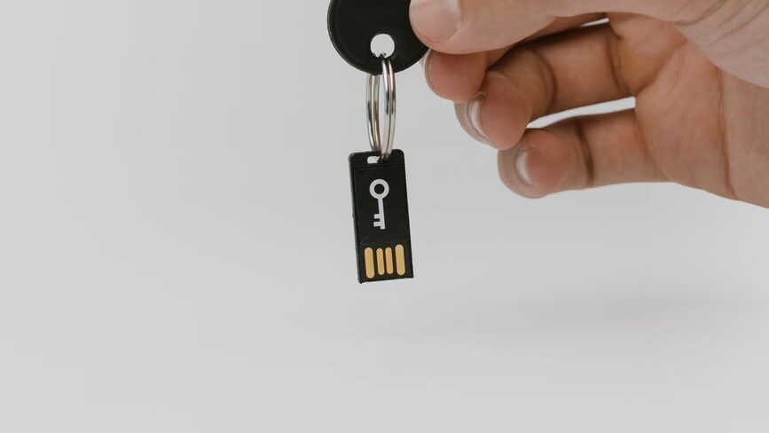 hand holding a key with a usb flash drive